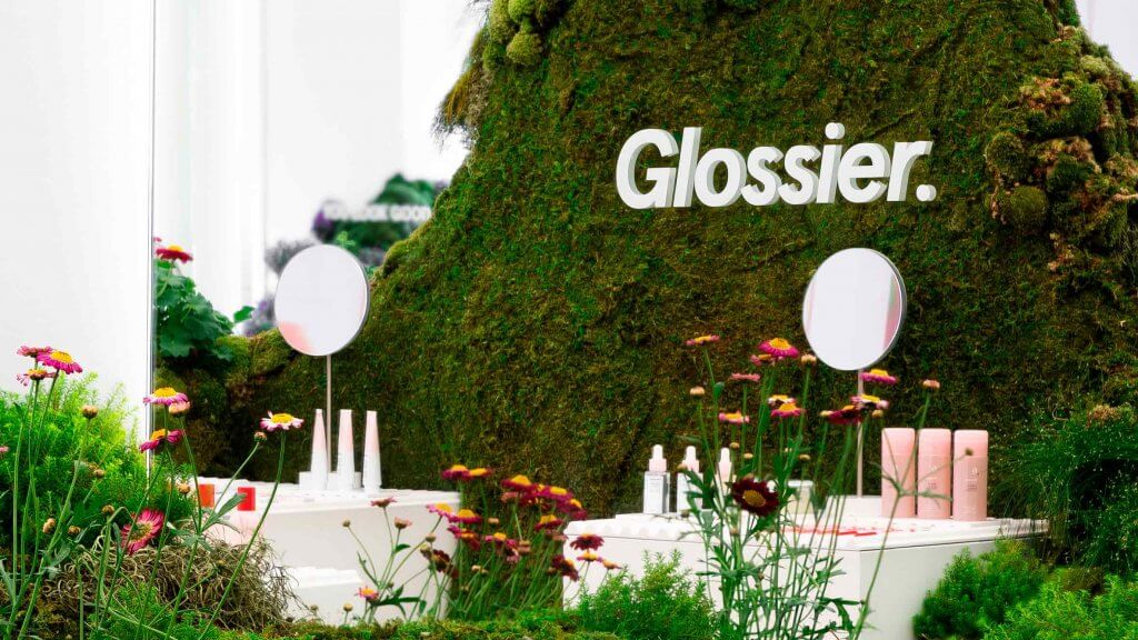 Diseño de vitrina para la marca de cosméticos Glossier, utilizando musgo, gramineas y flores.
